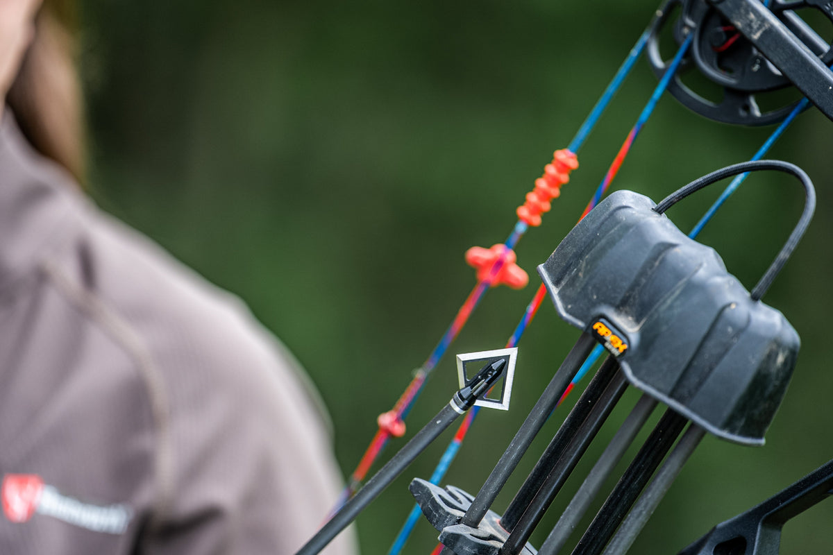 Magnus Black Hornet broadhead mounted on an arrow beside a bow quiver